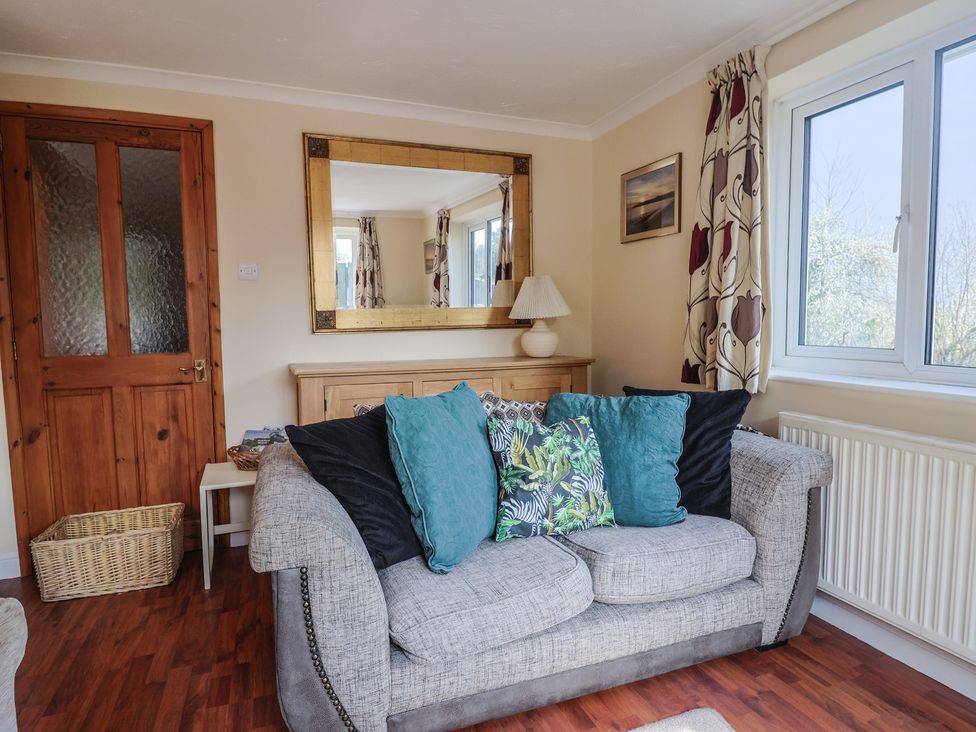 A living room with a sofa and cushions at Regenna in Seaton