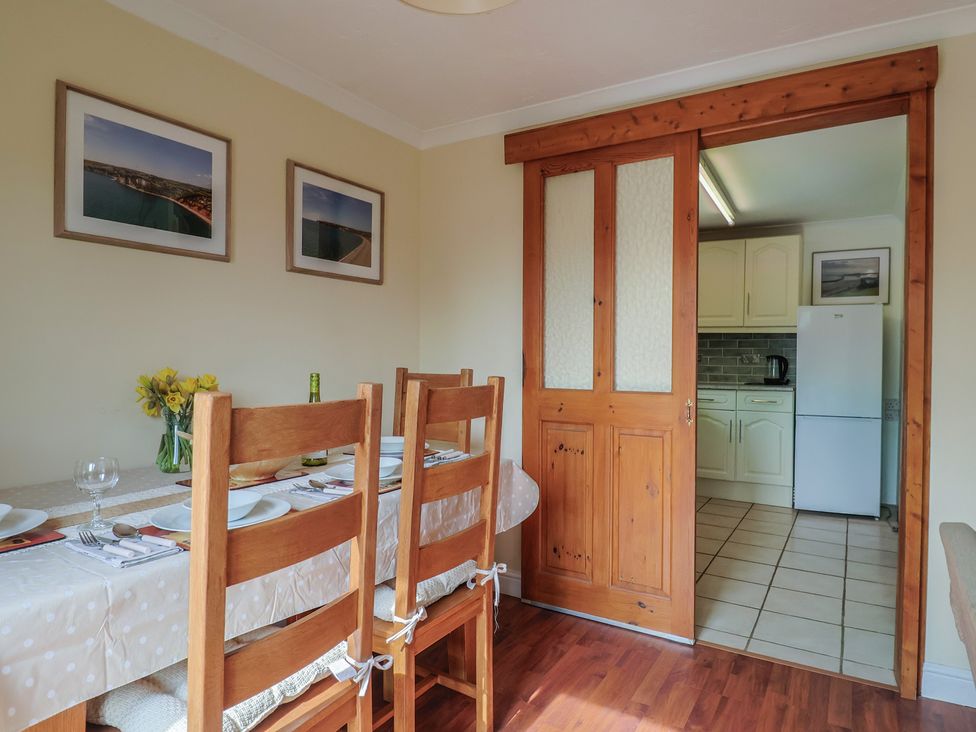 A dining room with a table set for dinner at Regenna in Seaton