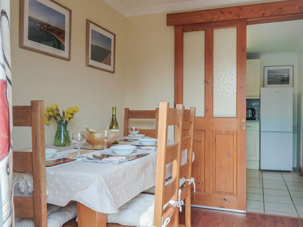 A dining area with a table set for meals at Regenna in Seaton