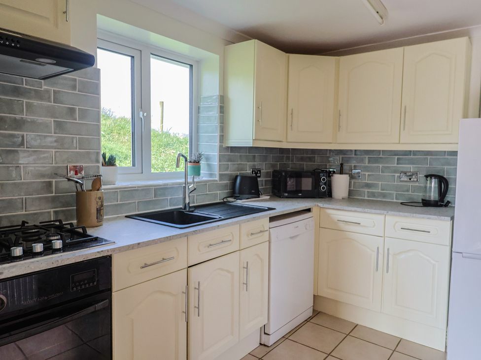 A kitchen with sink and appliances at Regenna in Seaton