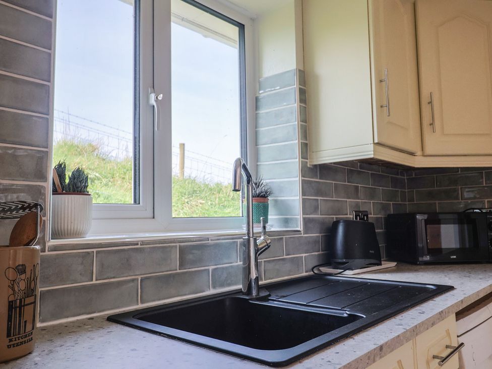A kitchen with a sink and window at Regenna in Seaton