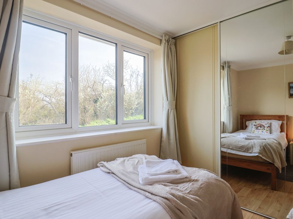 A bedroom with a bed and windows at Regenna in Seaton