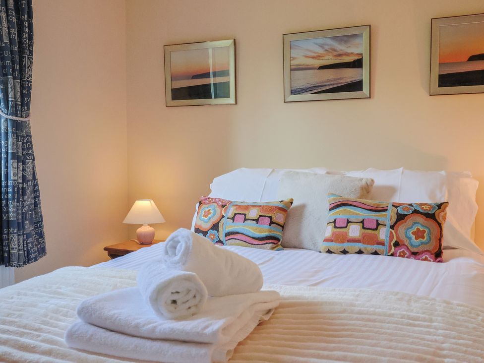 A bedroom with a bed and decorative pillows at Regenna in Seaton