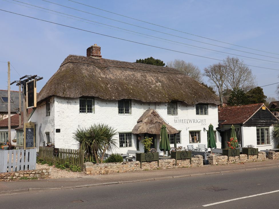 A building with thatched roof and patio at The Wheelwright in Seaton