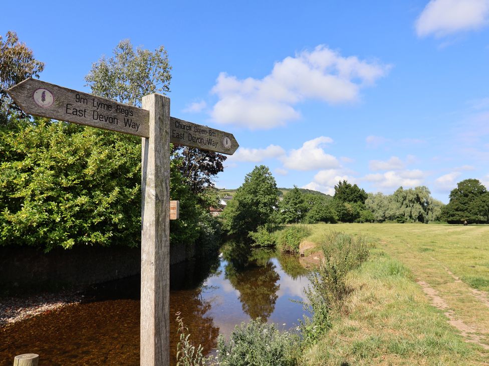 A directional sign near a stream in an outdoor area at Regenna in Seaton