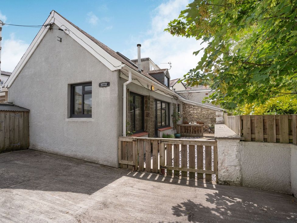 A house with a deck and tree at Brewery Cottage