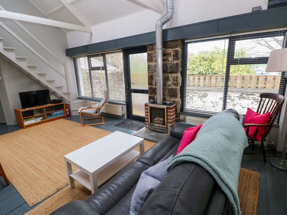 A living room with a sofa and coffee table at Brewery Cottage