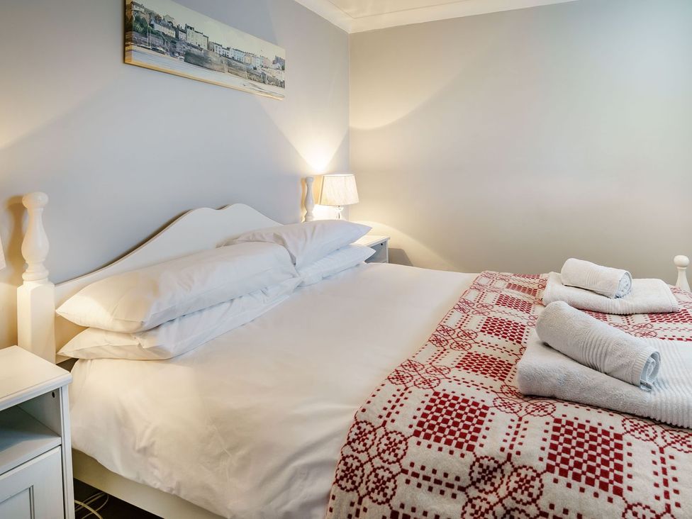 A bedroom with a bed and nightstand at Brewery Cottage