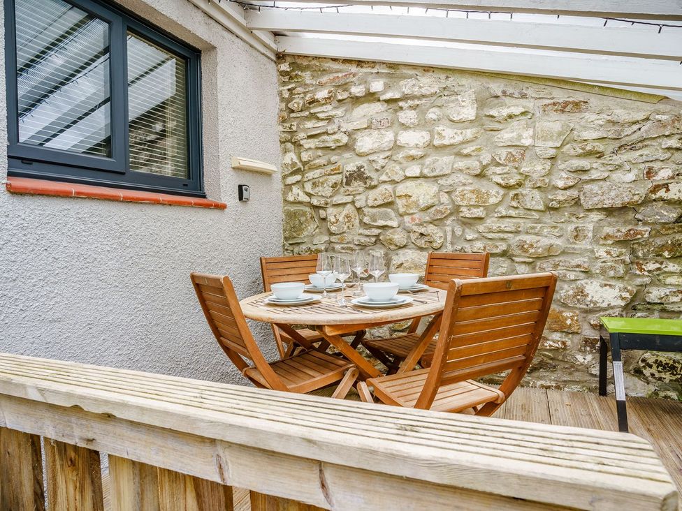 An outdoor dining area with a table and chairs at Brewery Cottage
