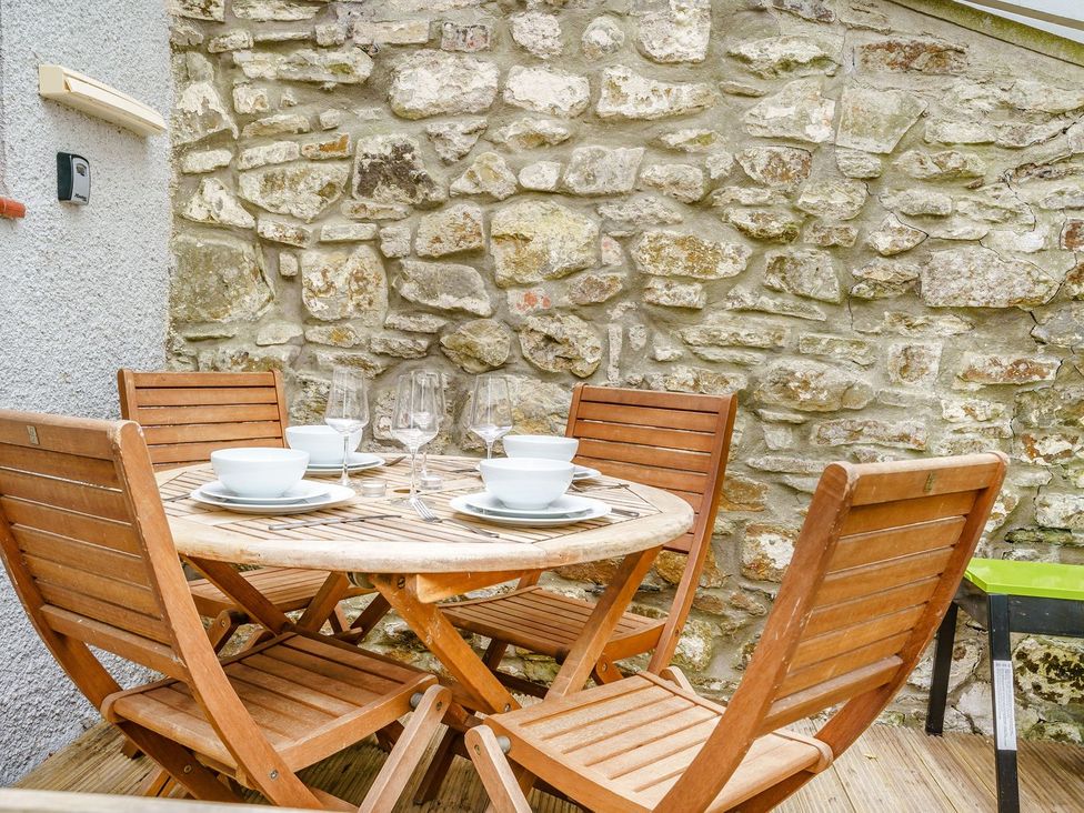 A dining table set with dishes and glasses at Brewery Cottage 