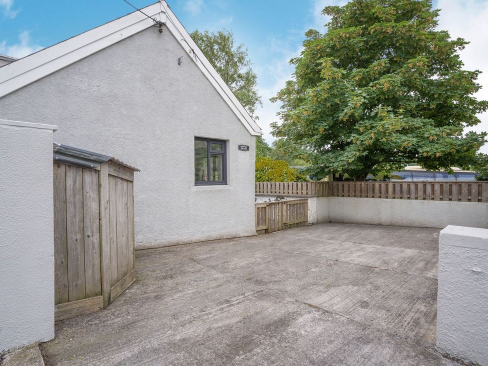 An outdoor area with a concrete surface and a shed at Brewery Cottage