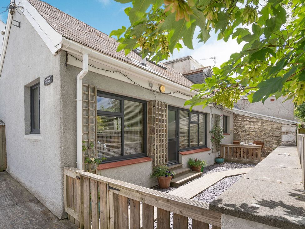 A house with windows and a door surrounded by a garden area at Brewery Cottage