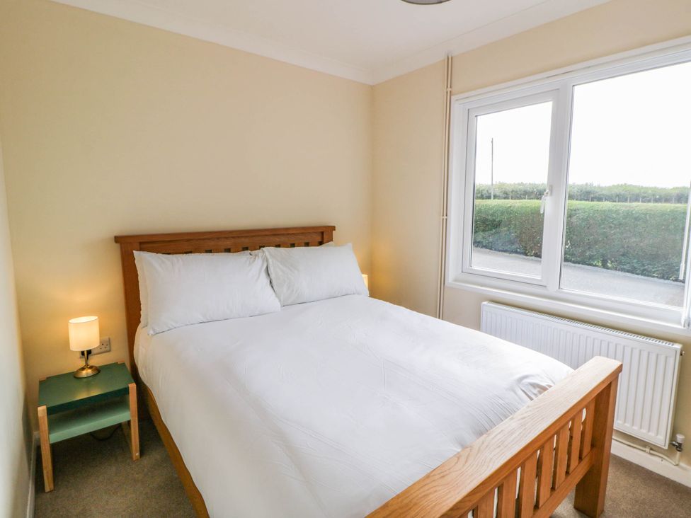 A bedroom with a double bed and lamp at The Croft in Llandrindod Wells
