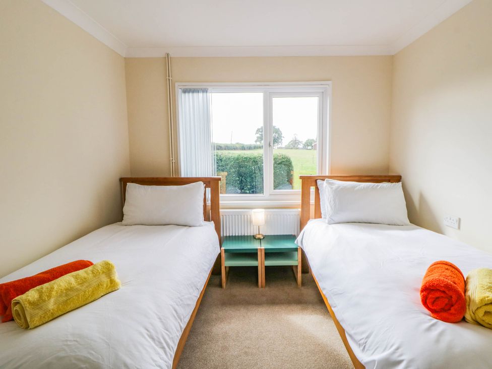 A bedroom with twin beds and a nightstand at The Croft in Llandrindod Wells