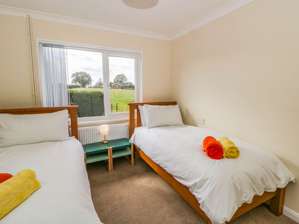 A bedroom with two beds and a lamp at The Croft in Llandrindod Wells