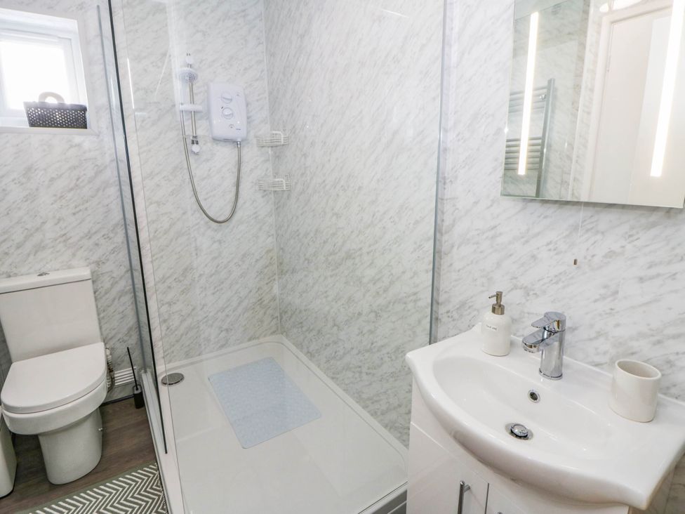 A bathroom with a shower, toilet, and sink at The Croft in Llandrindod Wells