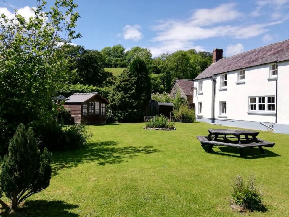 A garden with a picnic table and a shed at Picton House near St Clears