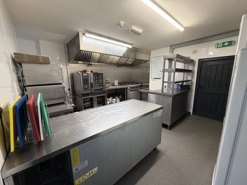 A commercial kitchen with stainless steel appliances at Picton House near St Clears
