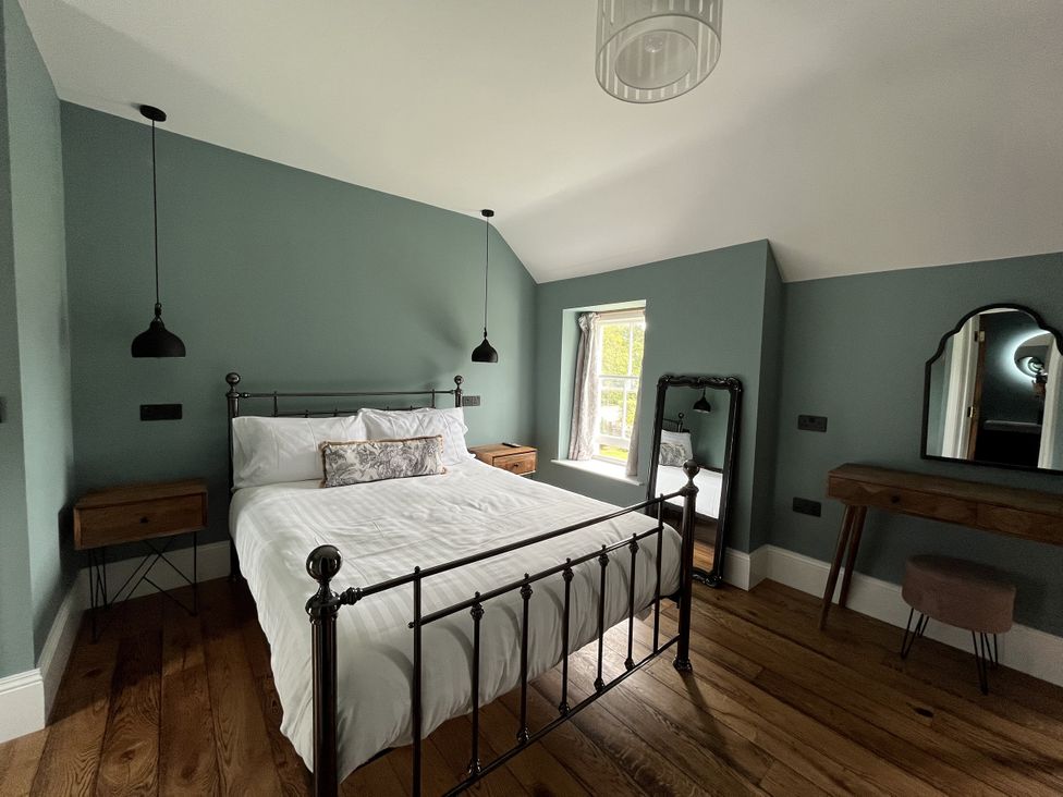 A bedroom with a bed and dressing table at Picton House near St Clears