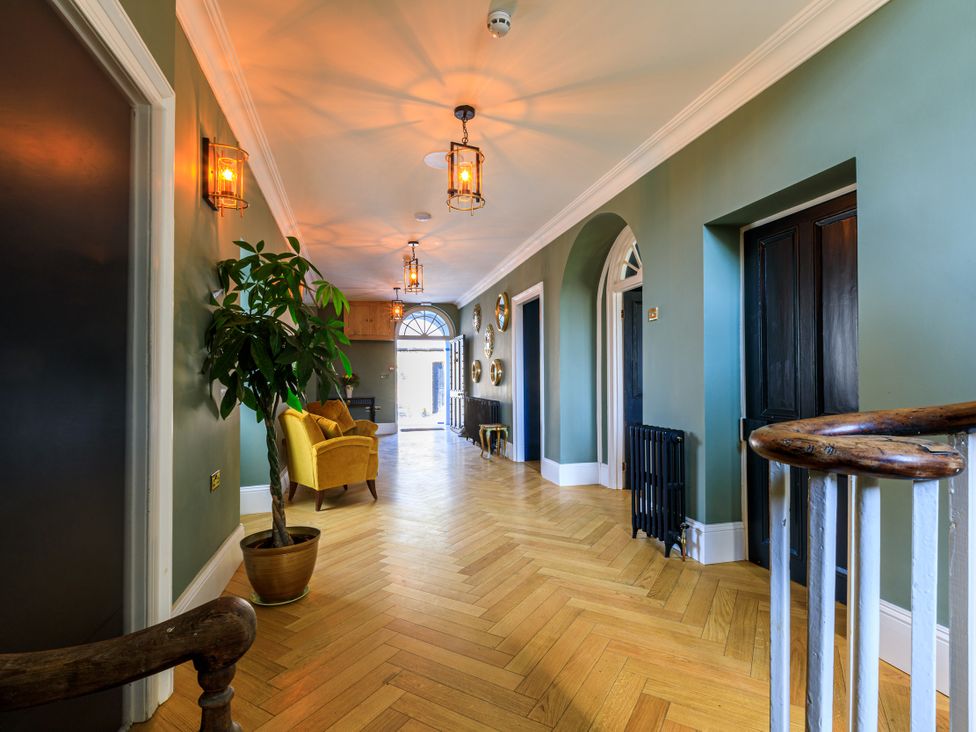 A hallway with a plant and an armchair at Picton House near St Clears