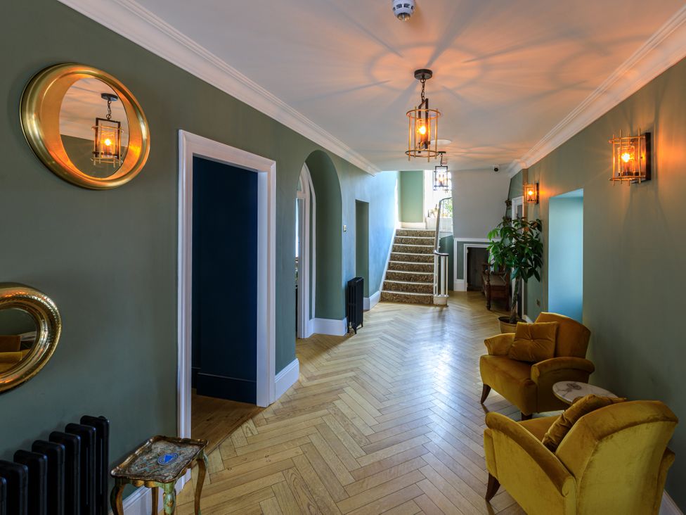 A hallway with a staircase and chairs at Picton House near St Clears