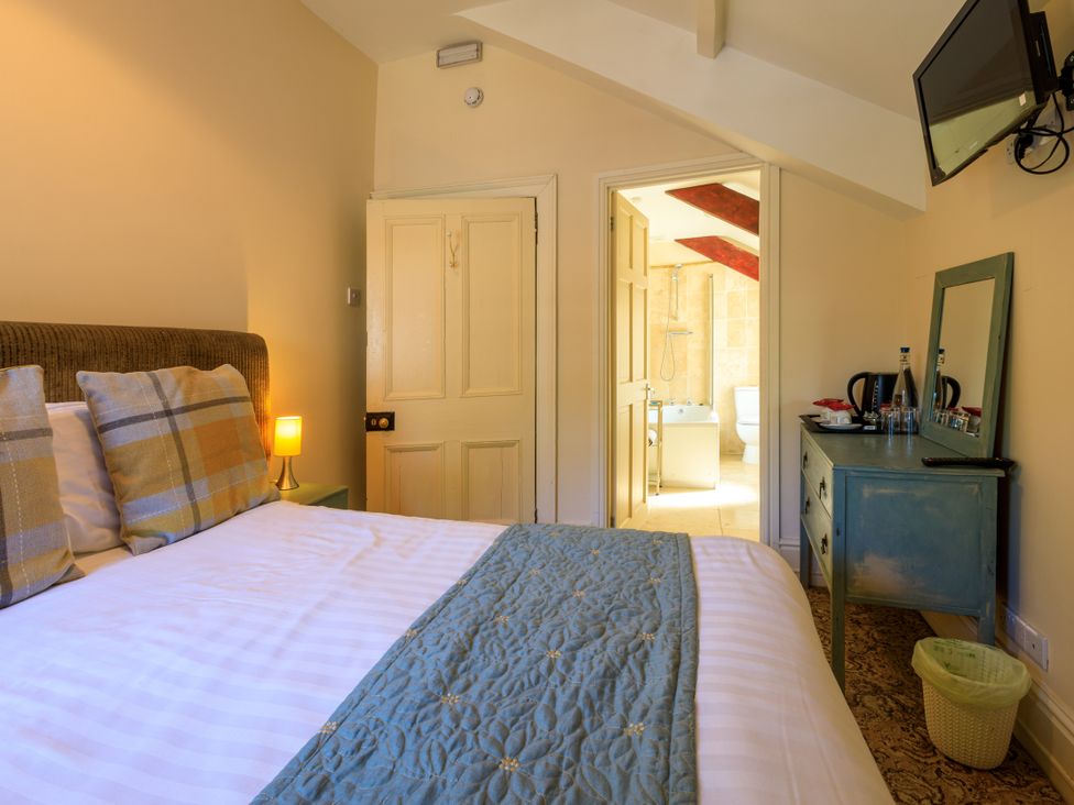 A bedroom with a bed and a bathroom view at Picton House near St Clears