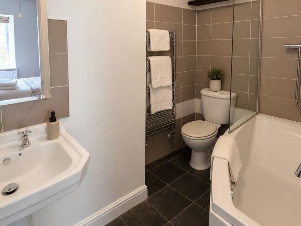 A bathroom with a sink, bathtub, and toilet at Coach House in St Clears