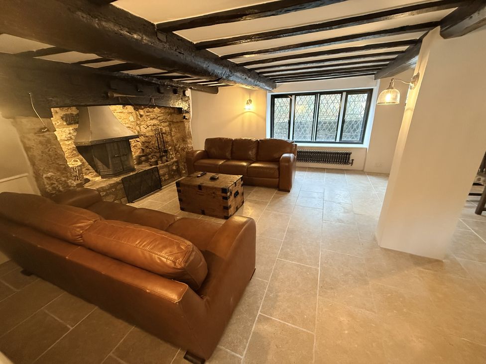 A living room with a fireplace and sofas at Bridge Cottage in Chideock