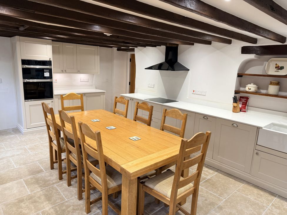 A kitchen with a wooden dining table and chairs at Bridge Cottage in Chideock