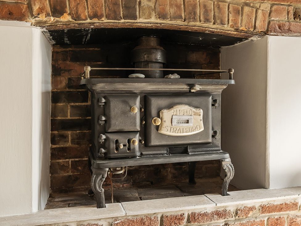 A wood stove in a brick alcove at Bridge Cottage in Chideock