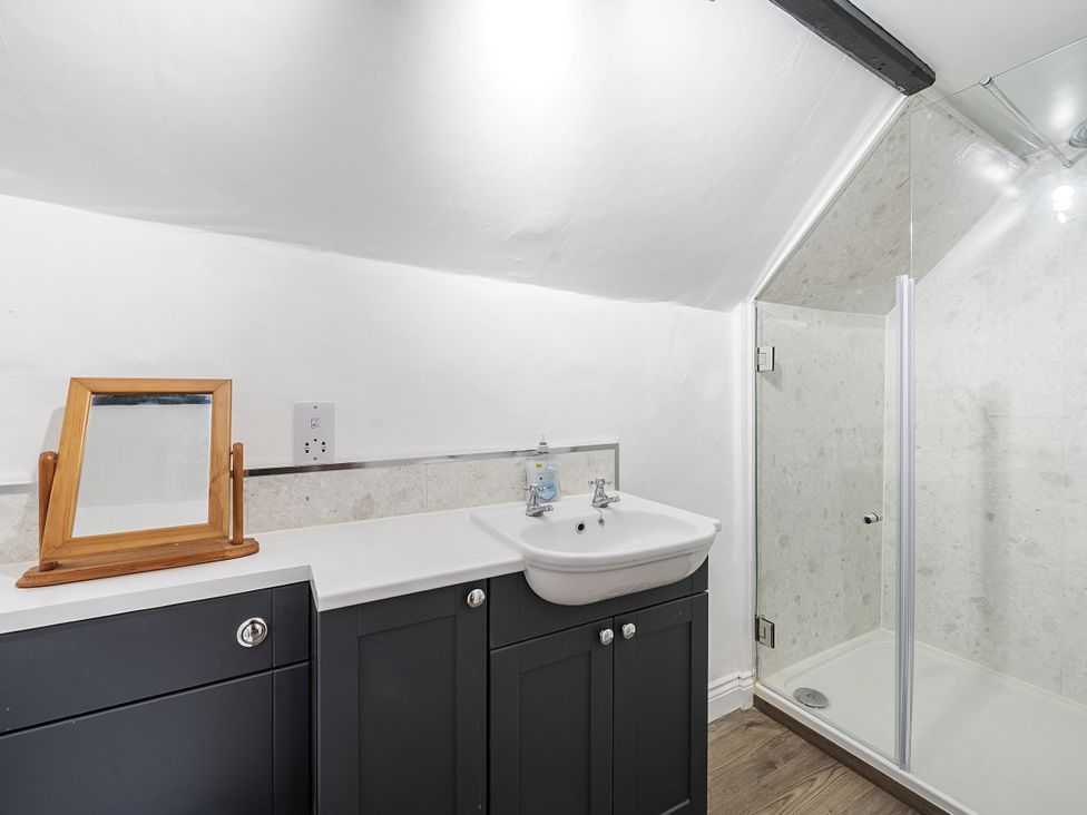 A bathroom with a sink and shower at Bridge Cottage in Chideock