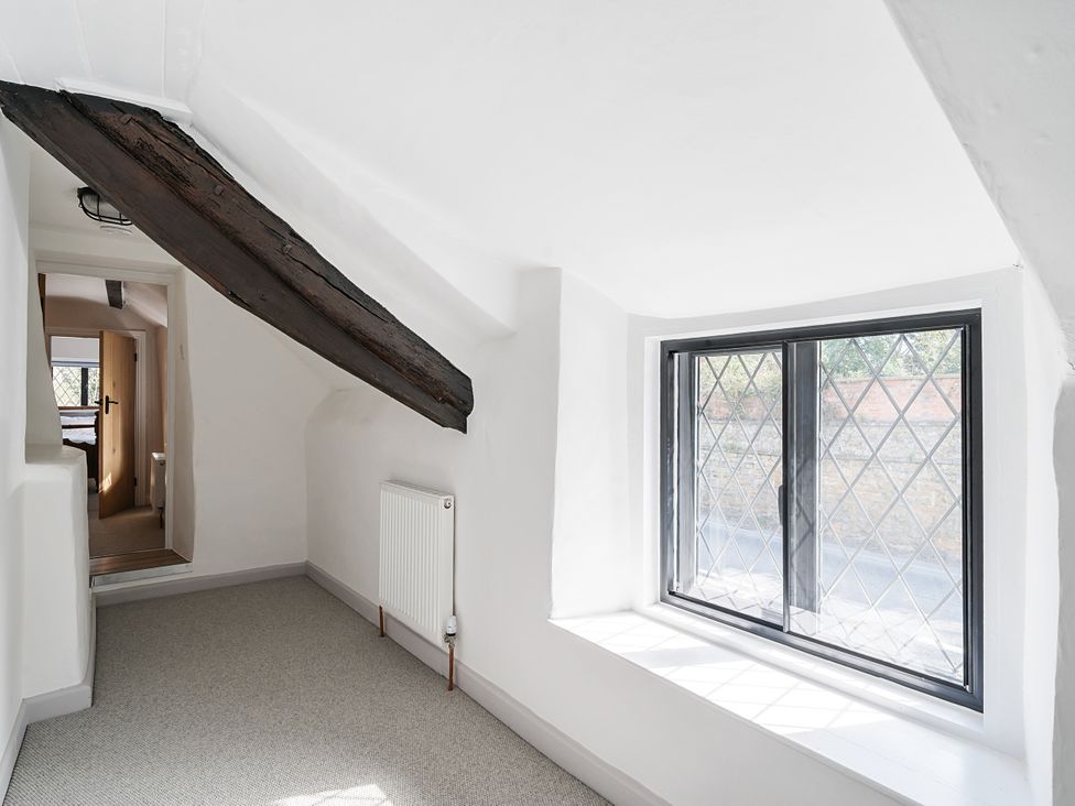 A hallway with a window and a doorway at Bridge Cottage in Chideock