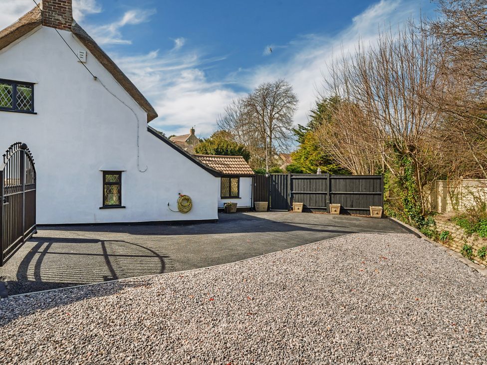 An outdoor area with a cottage and gravel driveway at Bridge Cottage in Chideock