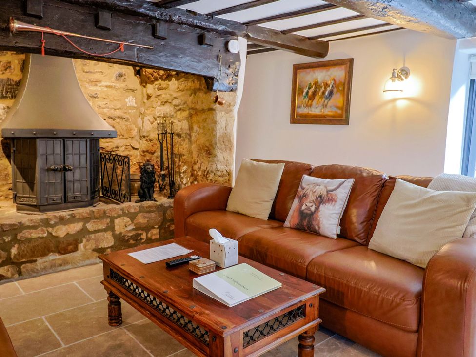 A living room with a sofa and fireplace at Bridge Cottage in Chideock