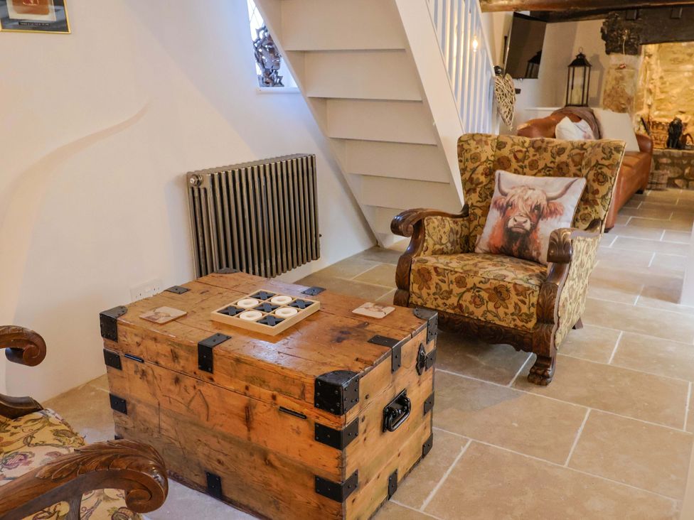 A living room with a coffee table and chairs at Bridge Cottage in Chideock