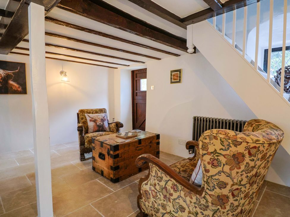 A living room with chairs and a table at Bridge Cottage in Chideock