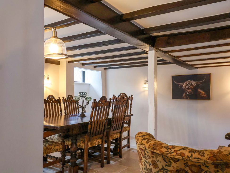 A dining room with a large table and chairs at Bridge Cottage in Chideock