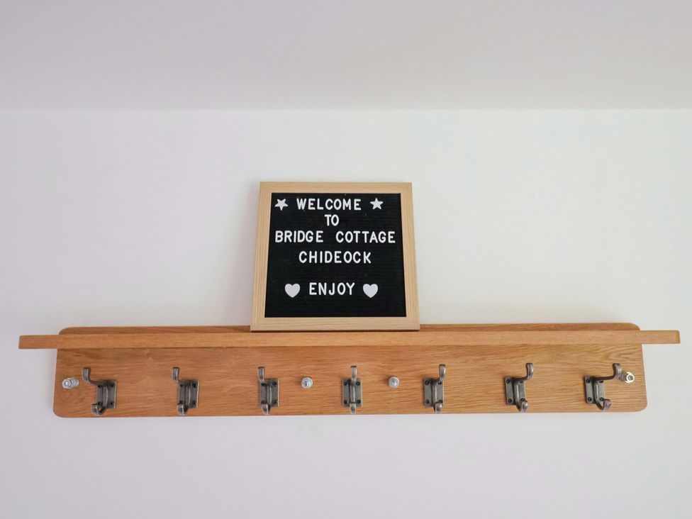 A hook rack with a welcome sign at Bridge Cottage Chideock