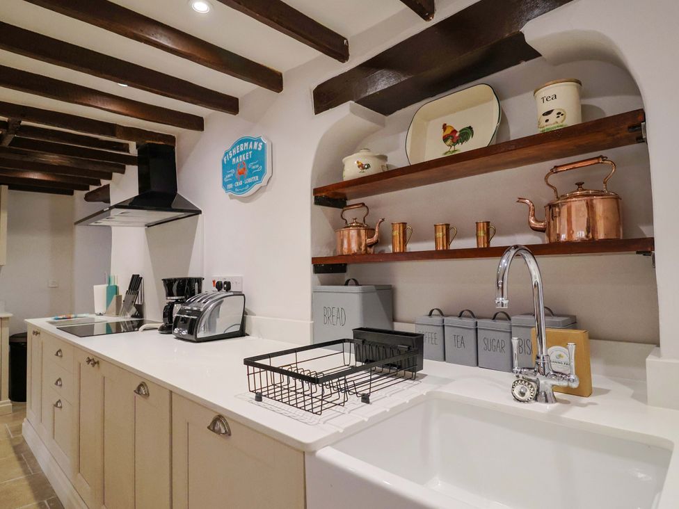 A kitchen with a sink and appliances at Bridge Cottage in Chideock