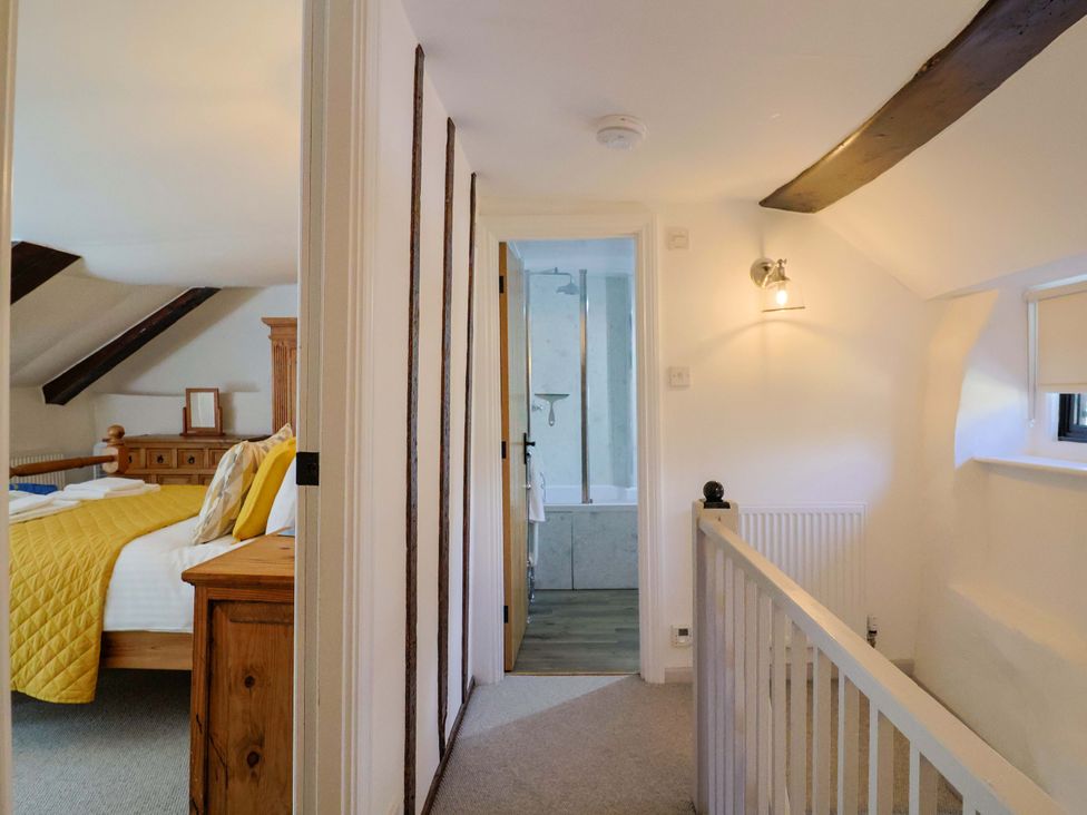A hallway with access to a bedroom and bathroom at Bridge Cottage in Chideock