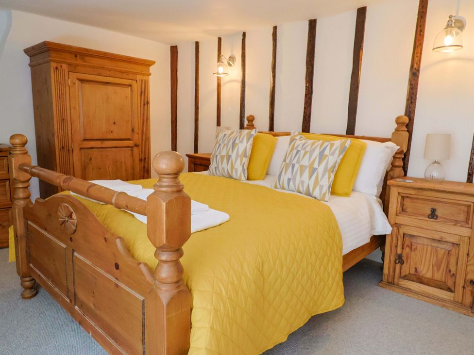 A bedroom with a bed and wardrobe at Bridge Cottage in Chideock