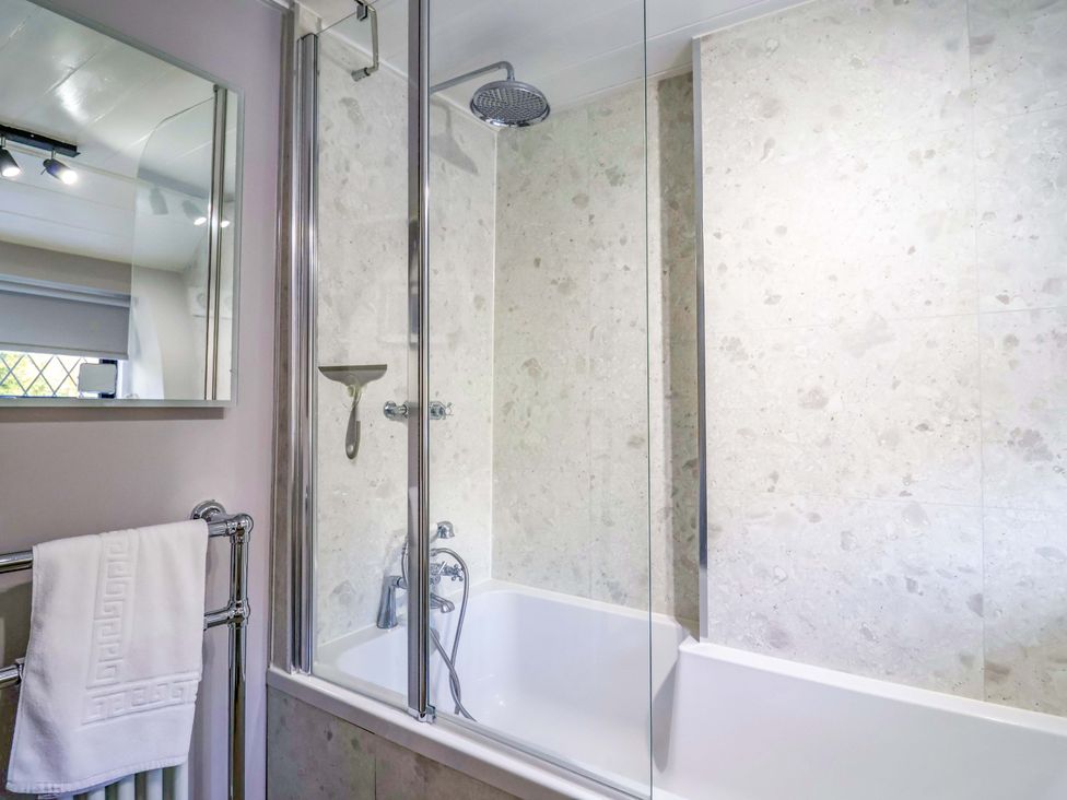 A bathroom with a bathtub and shower at Bridge Cottage in Chideock