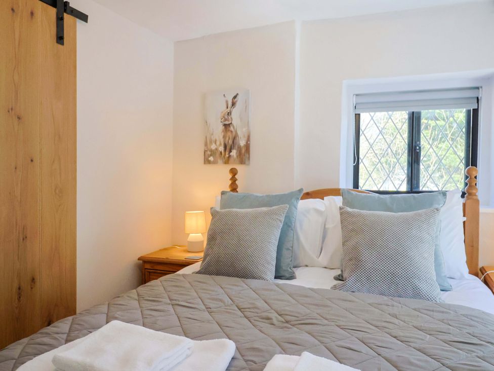 A bedroom with a bed and lamp at Bridge Cottage in Chideock