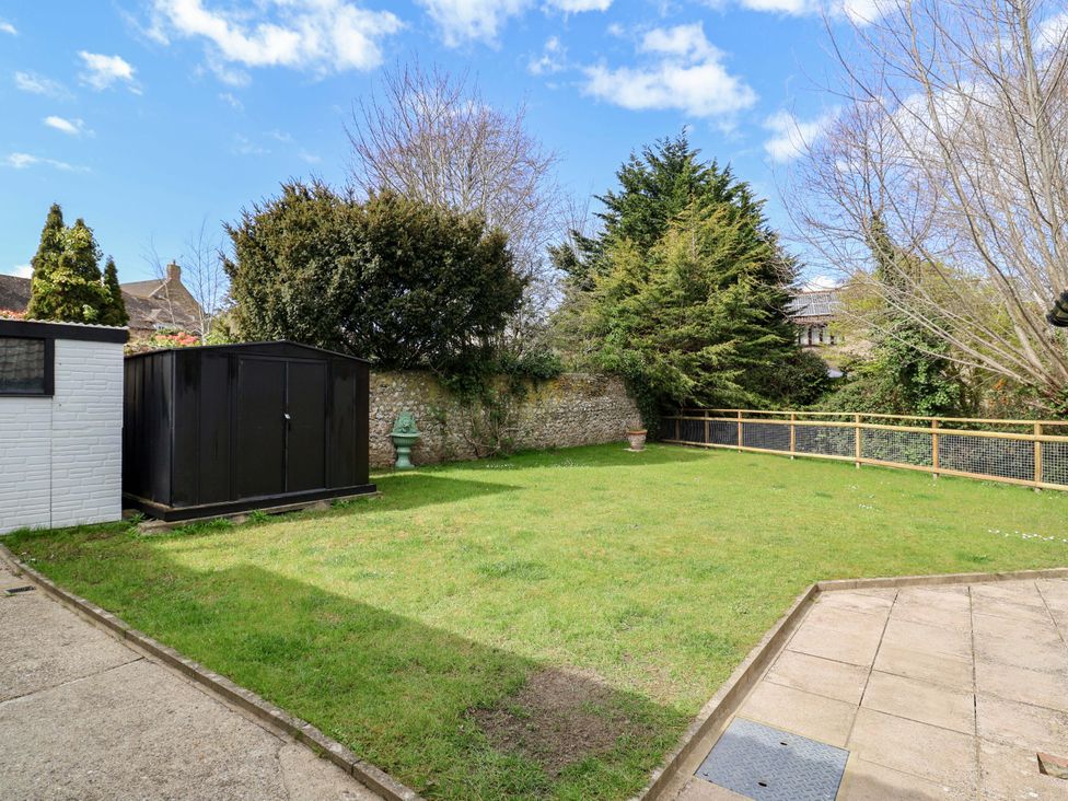 A garden with a shed and lawn at Bridge Cottage in Chideock