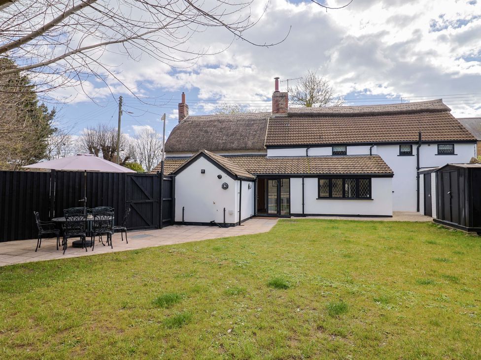 A garden with a patio and dining set at Bridge Cottage in Chideock