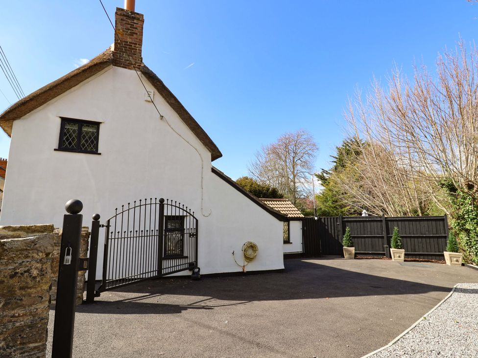 A house with a gate and driveway at Bridge Cottage in Chideock