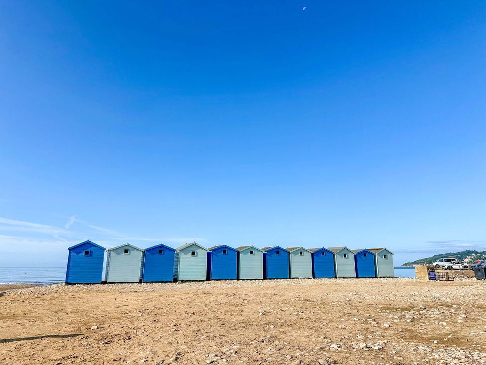 Beach huts on the sand by the ocean at Bridge Cottage in Chideock