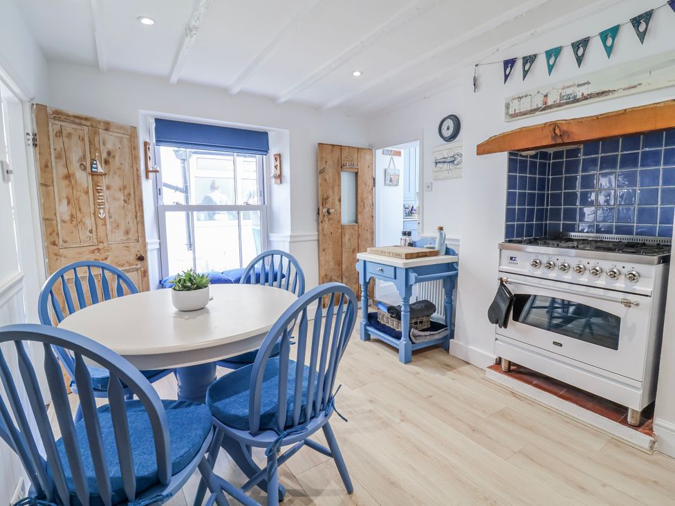 A kitchen with a dining table and chairs at Hideaway Cottage