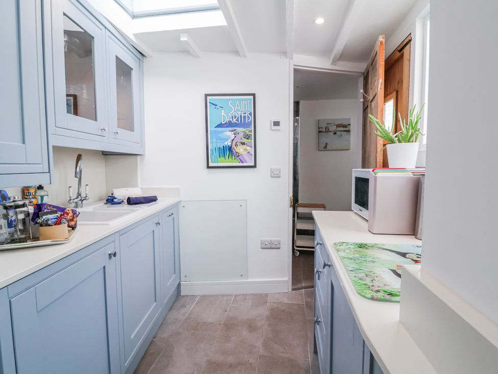 A kitchen with cabinets and a sink at Hideaway Cottage