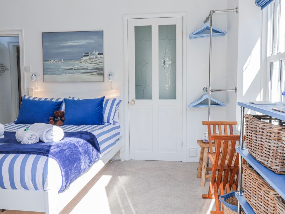 A bedroom with a bed and a chair at Hideaway Cottage